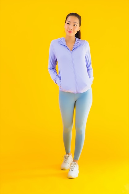 Portrait beautiful young asian sport woman ready for exercise on yellow