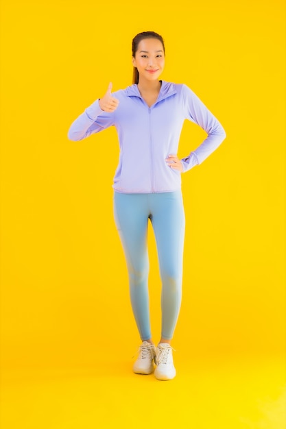 Portrait beautiful young asian sport woman ready for exercise on yellow