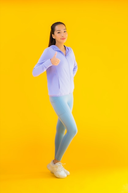 Portrait beautiful young asian sport woman ready for exercise on yellow