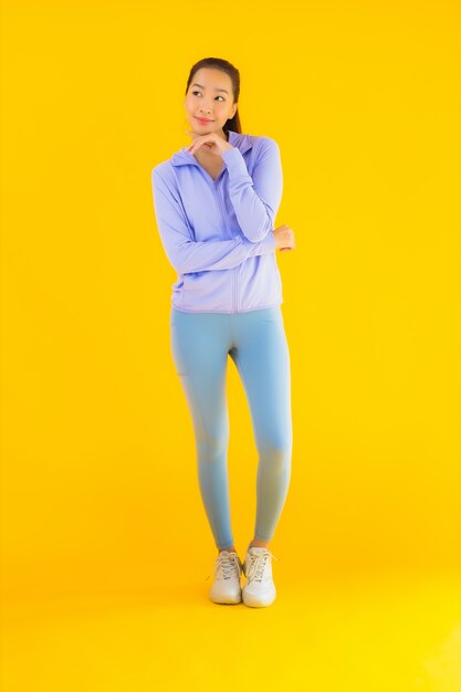 Portrait beautiful young asian sport woman ready for exercise on yellow