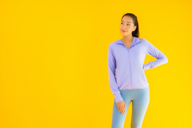 세로 아름 다운 젊은 아시아 스포츠 여자 노란색 운동 준비