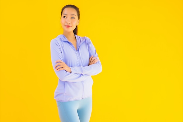 Portrait beautiful young asian sport woman ready for exercise on yellow