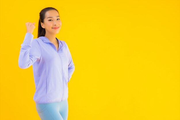 Portrait beautiful young asian sport woman ready for exercise on yellow