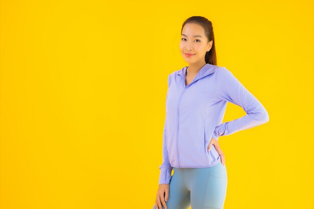 Portrait beautiful young asian sport woman ready for exercise on yellow