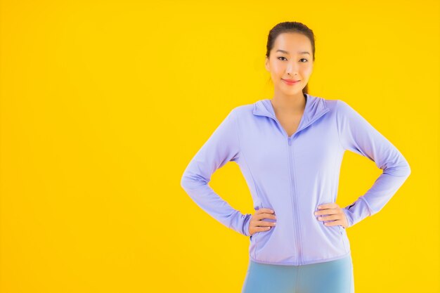 Portrait beautiful young asian sport woman ready for exercise on yellow