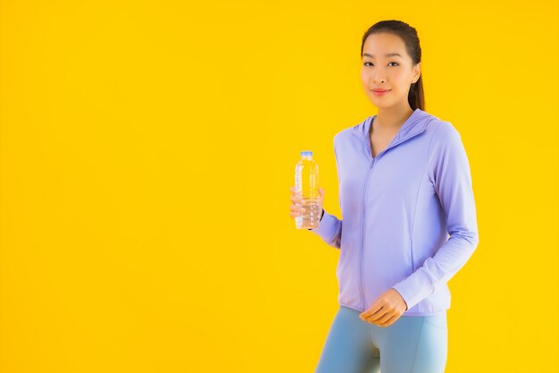 Portrait beautiful young asian sport woman ready for exercise on yellow