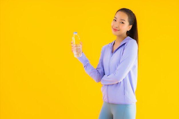 Portrait beautiful young asian sport woman ready for exercise on yellow