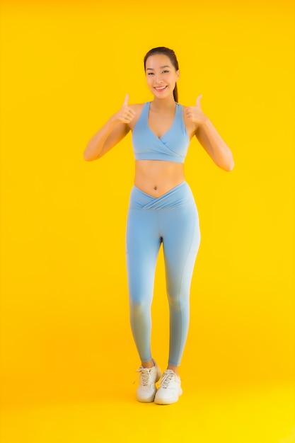 Portrait beautiful young asian sport woman ready for exercise on yellow