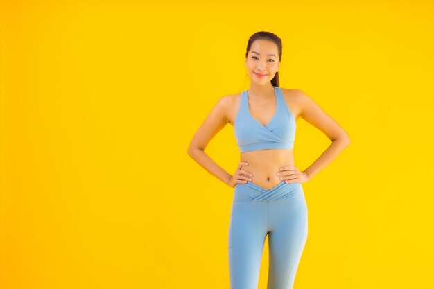 Portrait beautiful young asian sport woman ready for exercise on yellow