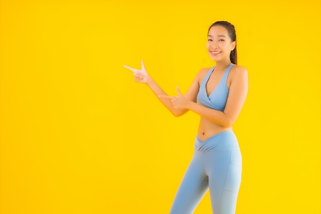 Portrait beautiful young asian sport woman ready for exercise on yellow