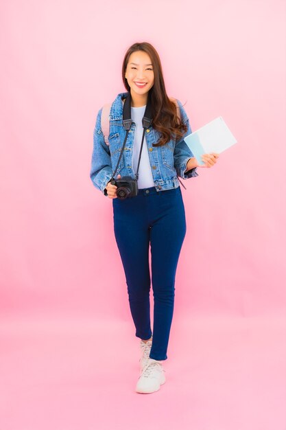 Portrait beautiful young asian woman backpack or luggage with camera ready for travel in vacation on pink wall