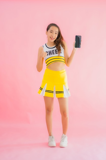 Free photo portrait beautiful young asian woman cheerleader with smart mobile phone