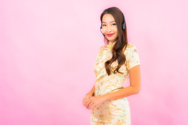 ピンク色の壁に肖像画美しい若いアジアの女性のカスタマーコールセンターケア