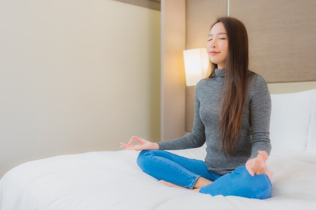 ベッドで瞑想をしている美しい若いアジアの女性の肖像画