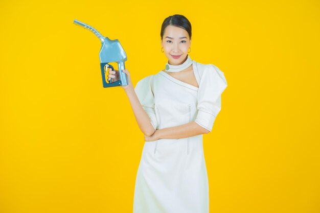 색상 배경에 초상화 아름 다운 젊은 아시아 여자 feul 가스 펌프