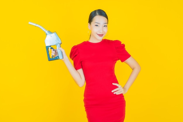 Portrait beautiful young asian woman feul gas pump on yellow
