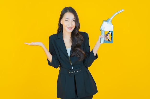 Portrait beautiful young asian woman feul gas pump on yellow