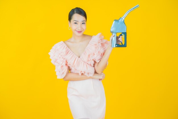 Portrait beautiful young asian woman feul gas pump on yellow