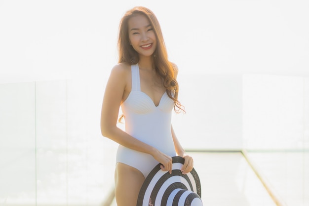 Free photo portrait beautiful young asian woman happy and smile on the beach sea and ocean