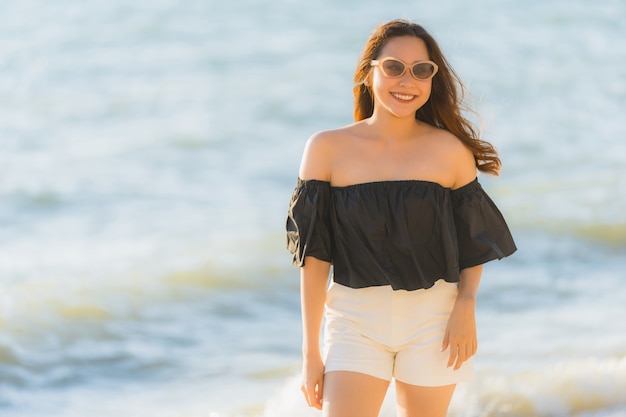 Ritratto bella giovane donna asiatica felice e sorriso sulla spiaggia mare e oceano