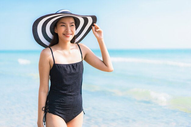 Женщина портрета красивая молодая азиатская счастливая и улыбка на пляже и море