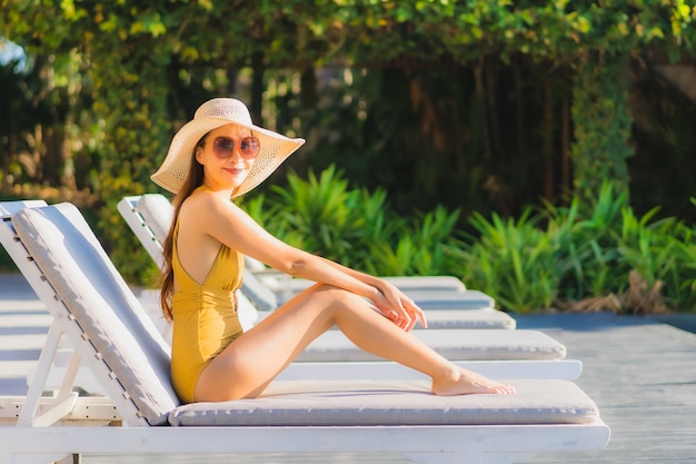 Portrait beautiful young asian woman happy smile relax around outdoor swimming pool in hotel resort