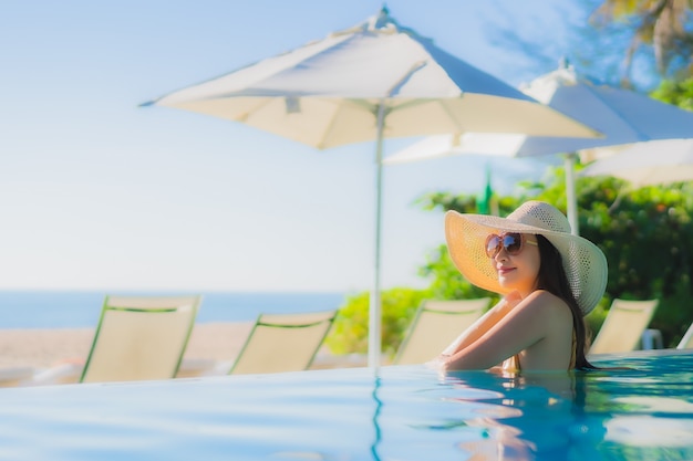 초상화 아름 다운 젊은 아시아 여자 행복 한 미소 호텔 리조트 야외 수영장 주위 휴식