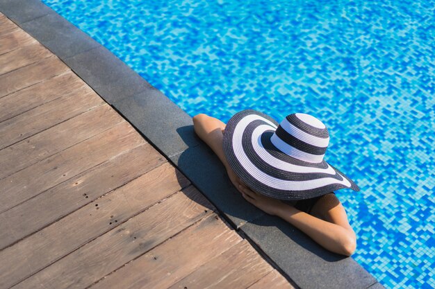 Portrait beautiful young asian woman happy smile relax around swimming pool in hotel resort