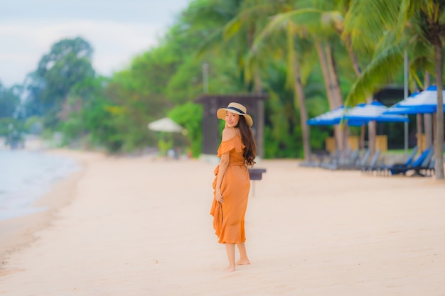 Free photo portrait beautiful young asian woman happy smile relax on the beach sea ocean