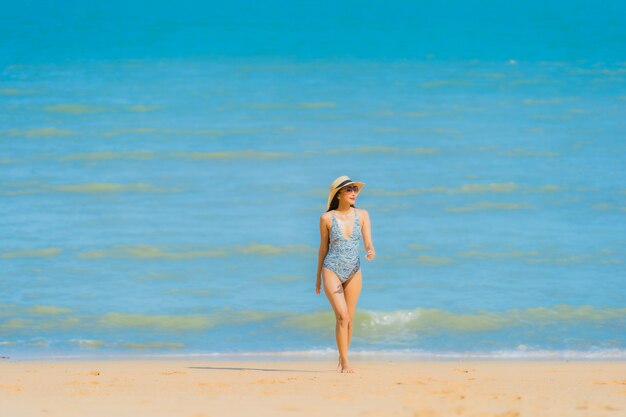 Portrait beautiful young asian woman happy smile relax on the tropical beach sea ocean for leisure travel