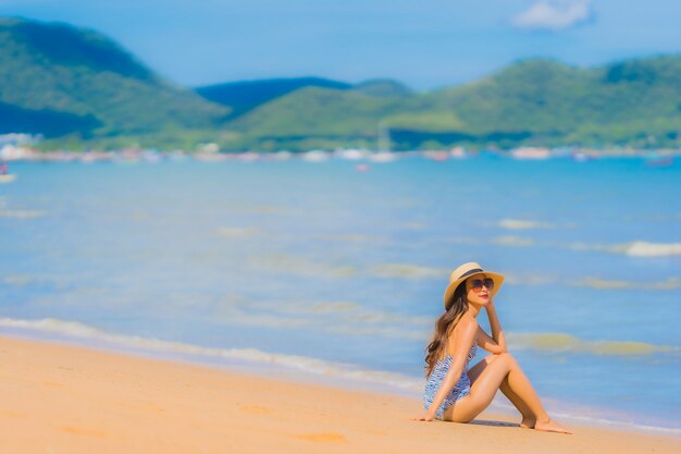 Portrait beautiful young asian woman happy smile relax on the tropical beach sea ocean for leisure travel
