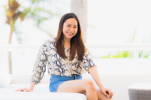 Portrait beautiful young asian woman happy and smile with travel in hotel resort neary sea and beach