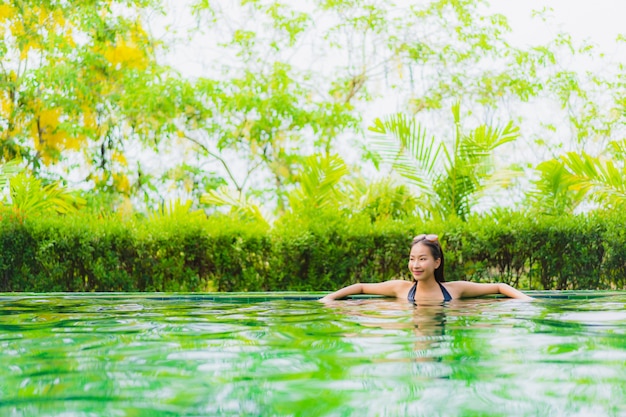 Бесплатное фото Женщина портрета красивая молодая азиатская в бассейне вокруг гостиницы и курорта