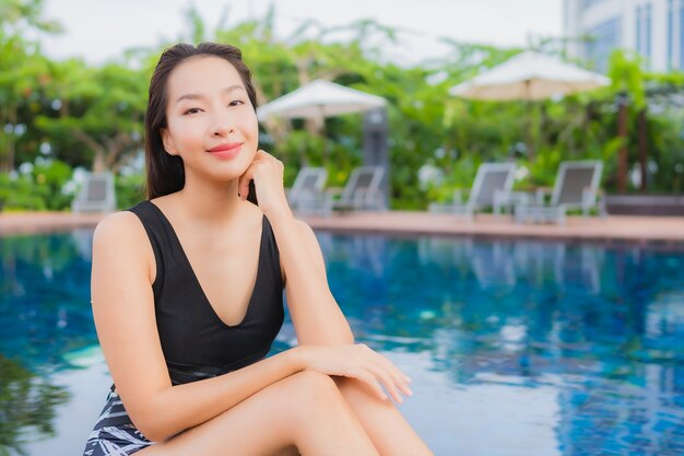 초상화 아름 다운 젊은 아시아 여자 레저 휴가 야외 수영장 주위 미소를 휴식