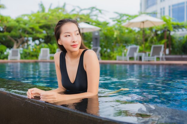 초상화 아름 다운 젊은 아시아 여자 레저 휴가 야외 수영장 주위 미소를 휴식