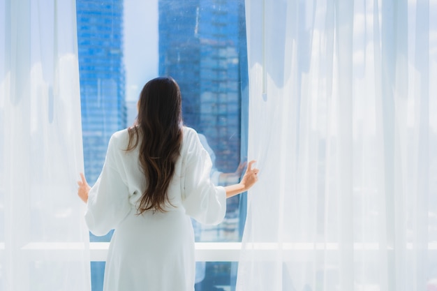 portrait beautiful young asian woman look outside of window for the view