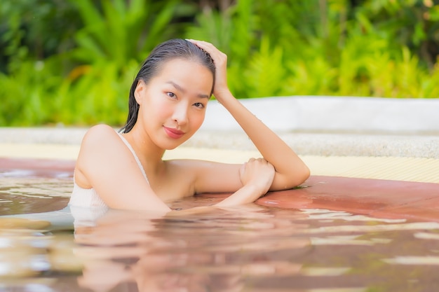 Portrait beautiful young asian woman relax around outdoor swimming pool in resort