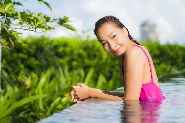 肖像画の美しい若いアジア女性リラックス休暇休暇で屋外スイミングプールの周りをお楽しみください。