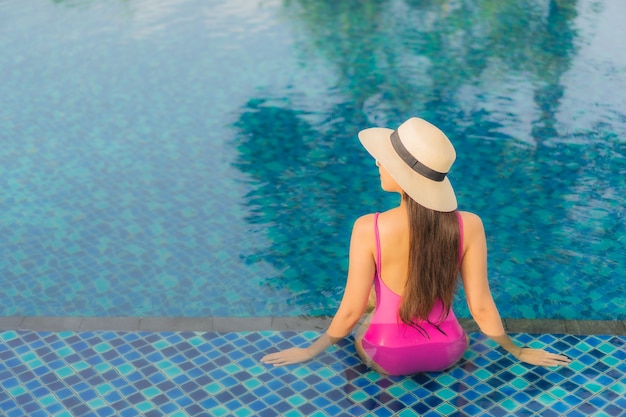 초상화 아름 다운 젊은 아시아 여자 휴식 휴가 휴가에 야외 수영장 주변에서 즐길 수