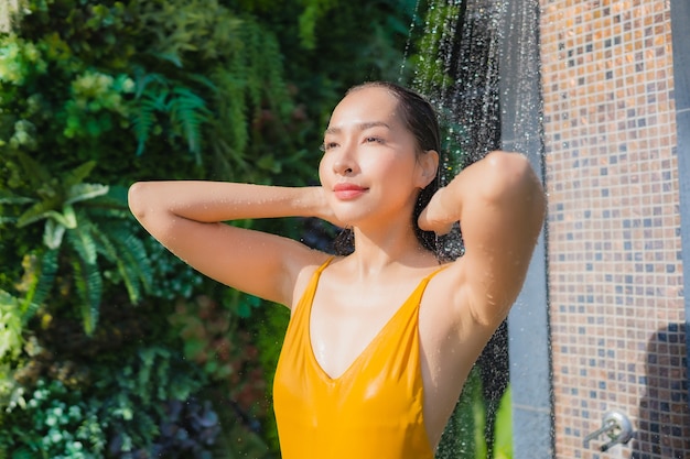 Portrait beautiful young asian woman relax happy smile around outdoor swimming pool in hotel resort for leisure vacation