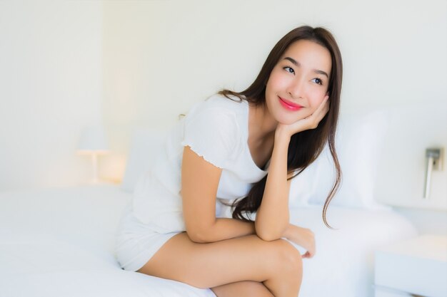 Portrait beautiful young asian woman relax happy smile on bed with white pillow blanket