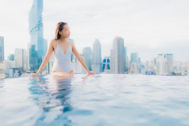 Portrait beautiful young asian woman relax happy smile leisure around outdoor swimming pool