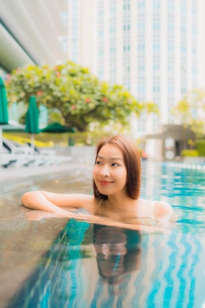 Portrait beautiful young asian woman relax happy smile leisure around outdoor swimming pool