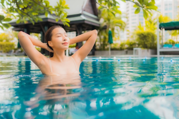 Portrait beautiful young asian woman relax happy smile leisure around outdoor swimming pool