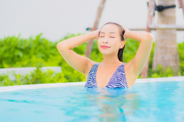 Portrait beautiful young asian woman relax leisure around outdoor swimming pool with sea ocean beach