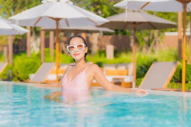 Portrait beautiful young asian woman relax leisure around outdoor swimming pool with sea