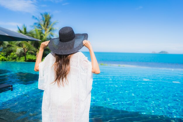 Portrait beautiful young asian woman relax in luxury outdoor swimming pool in hotel resort nearly beach sea ocean