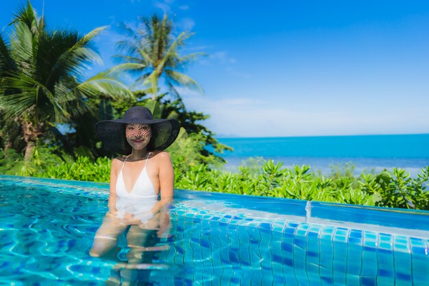 초상화 아름 다운 젊은 아시아 여자 호텔 리조트 거의 해변 바다 바다에서 럭셔리 야외 수영장에서 휴식