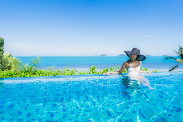 Portrait beautiful young asian woman relax in luxury outdoor swimming pool in hotel resort nearly beach sea ocean