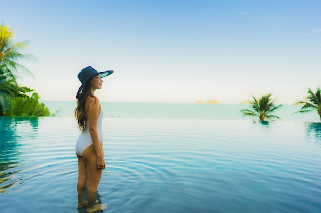 초상화 아름 다운 젊은 아시아 여자 호텔 리조트 거의 해변 바다 바다에서 럭셔리 야외 수영장에서 휴식